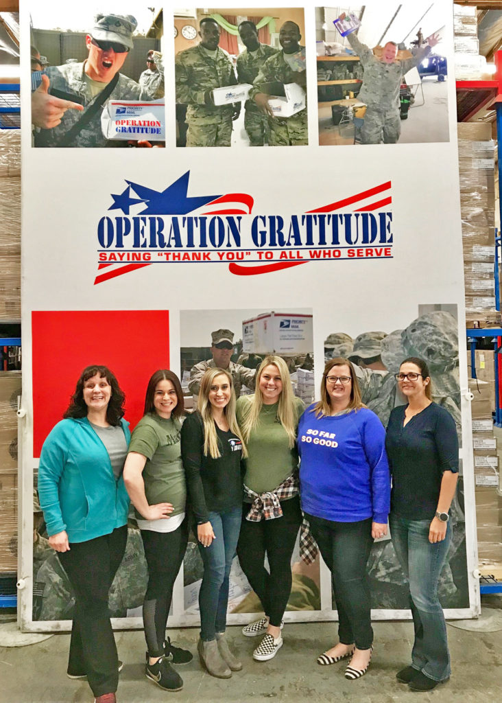 Military Spouses of Operation Gratitude stand together at the Operation Gratitude warehouse