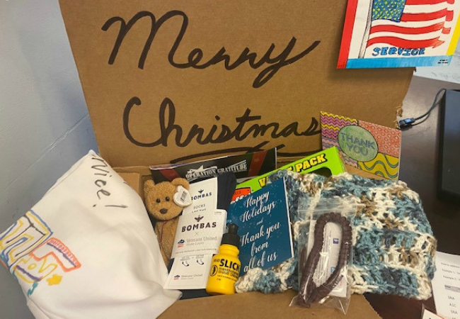Handwritten letters, paracord bracelet, and hygiene items in a Holiday care package sent to deployed US troops.