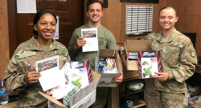 Deployed US troops showing letters of gratitude in their Holiday care packages.