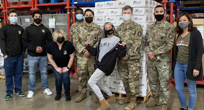 Operation Gratitude volunteers stand with care packages.