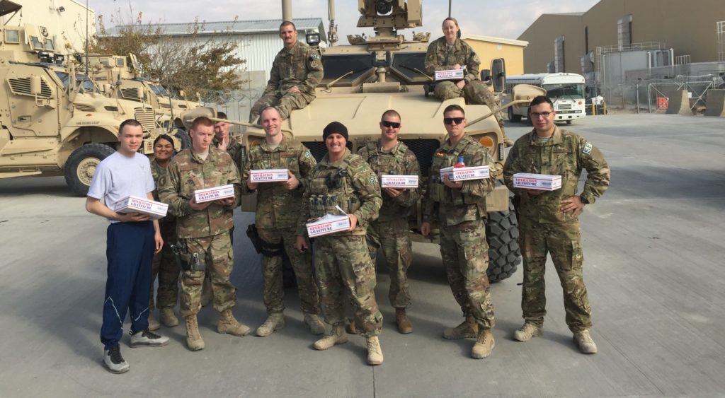 U.S. Soldiers holding Operation Gratitude care packages.