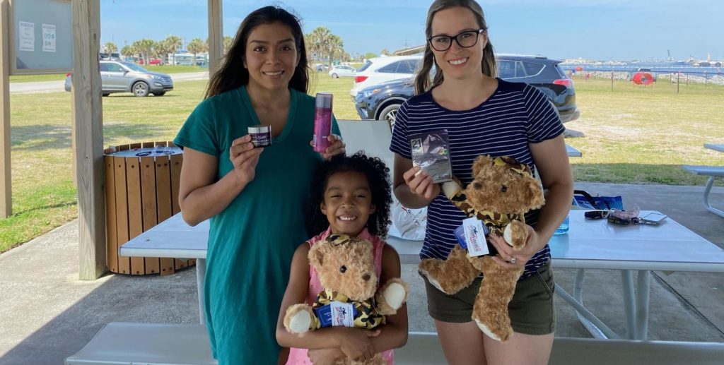 Military family members show the contents of their Operation Gratitude care package.