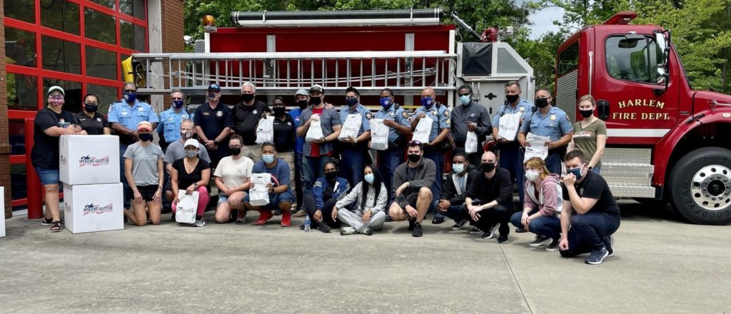 First responder heroes stand in front of a fire truck with Operation Gratitude care packages.