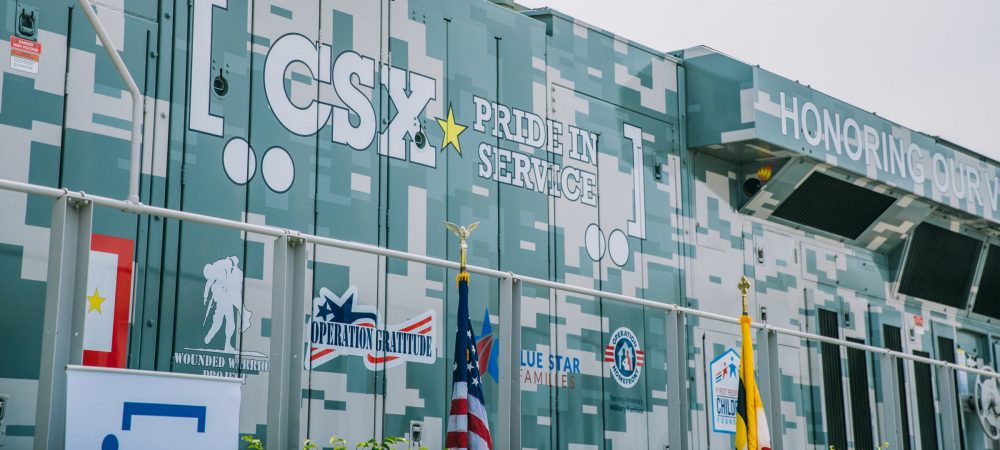 CSX train with veteran service organization nonprofit logos.