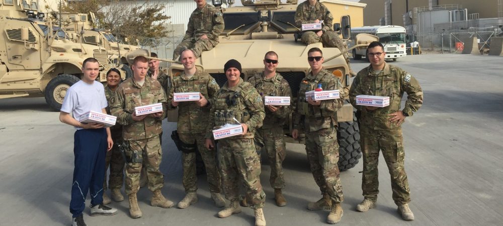 U.S. Soldiers holding Operation Gratitude care packages.