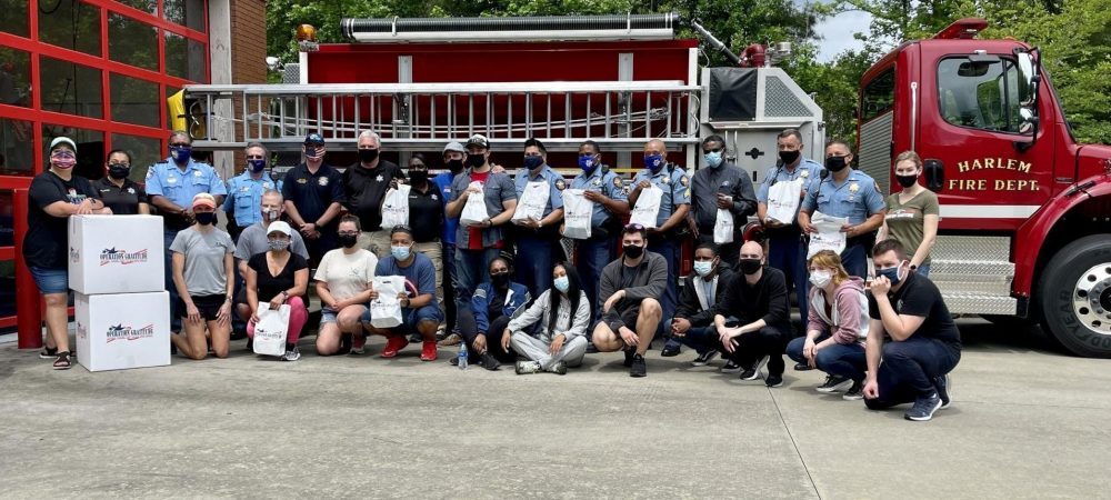 First responder heroes stand in front of a fire truck with Operation Gratitude care packages.